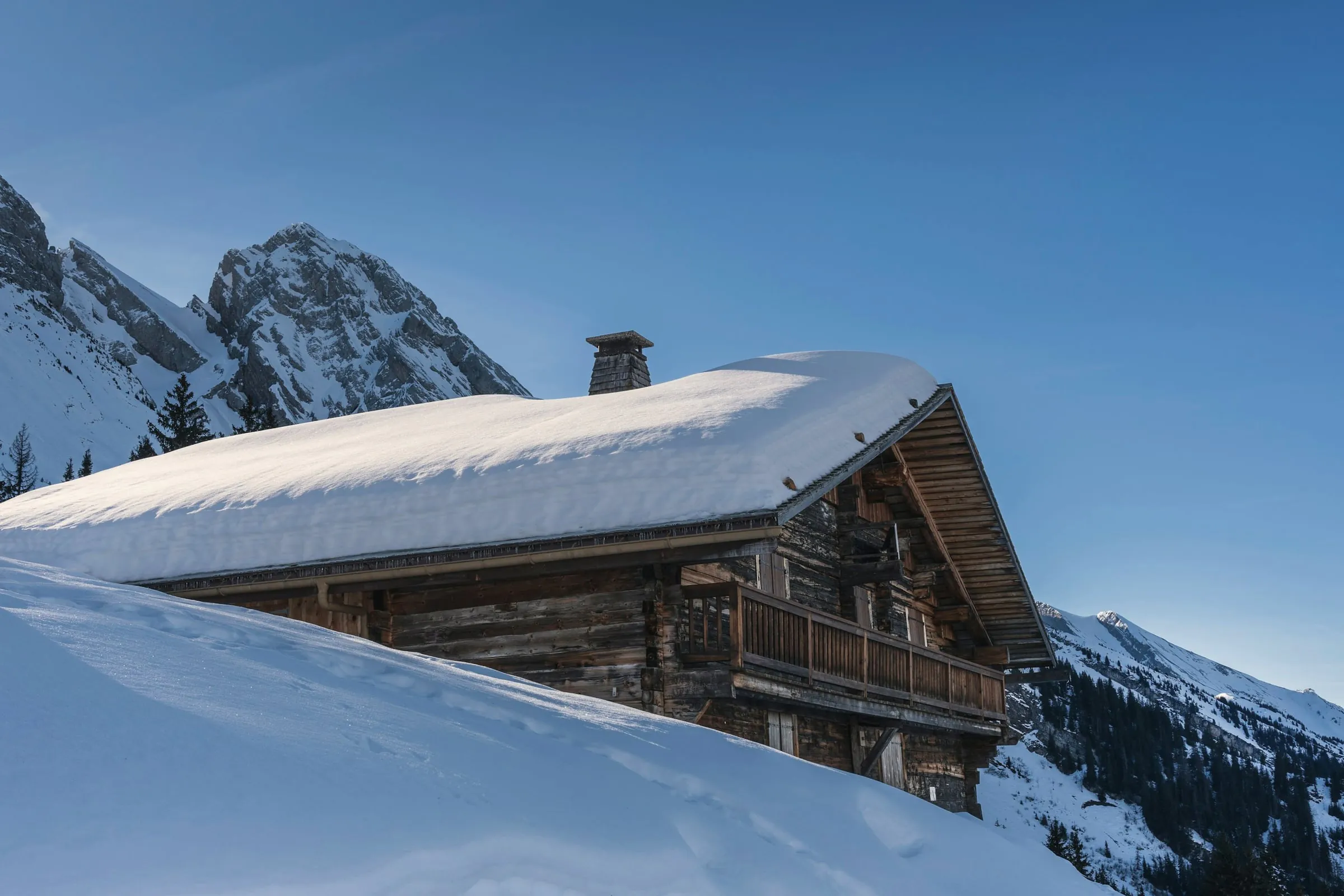 Chalet du Crêt sous la neige face aux sommets des Aravis